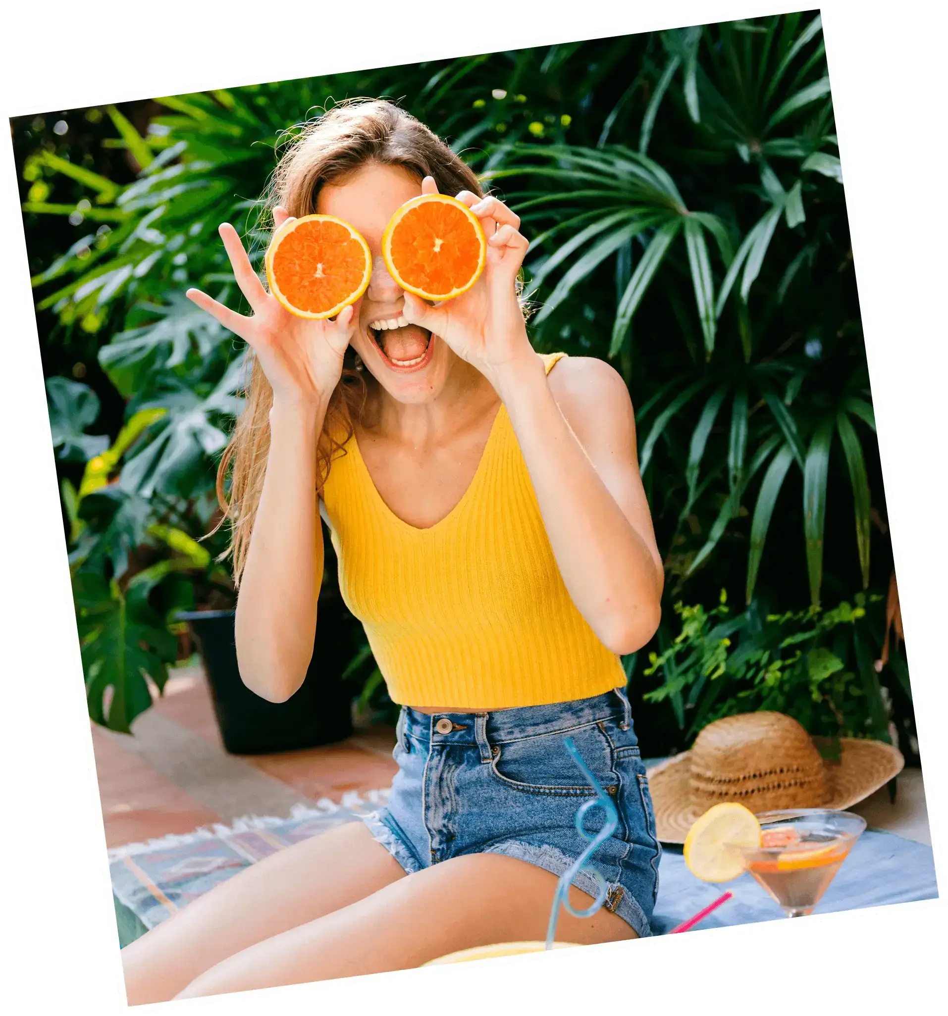 Woman with orange halves over eyes, summer picnic
