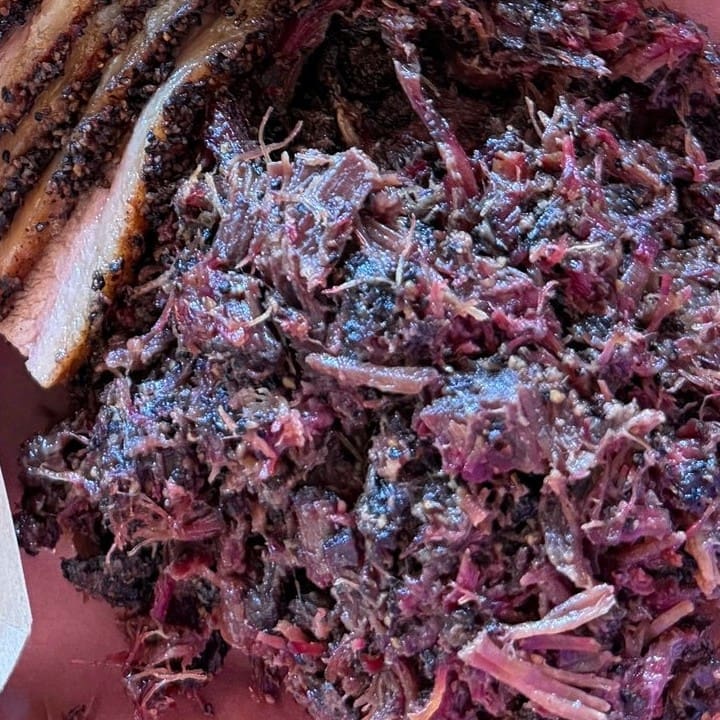 Chopped beef cheek at Zavala’s Barbecue with a dark black pepper bark, beside slices of brisket.
